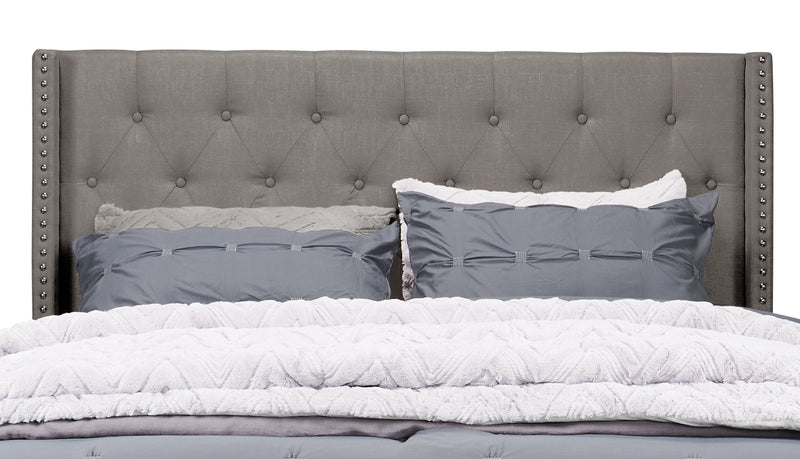 Lit rembourré à oreilles Brady en tissu gris clair avec clous décoratifs et capitonnage à boutons - format très grand lit