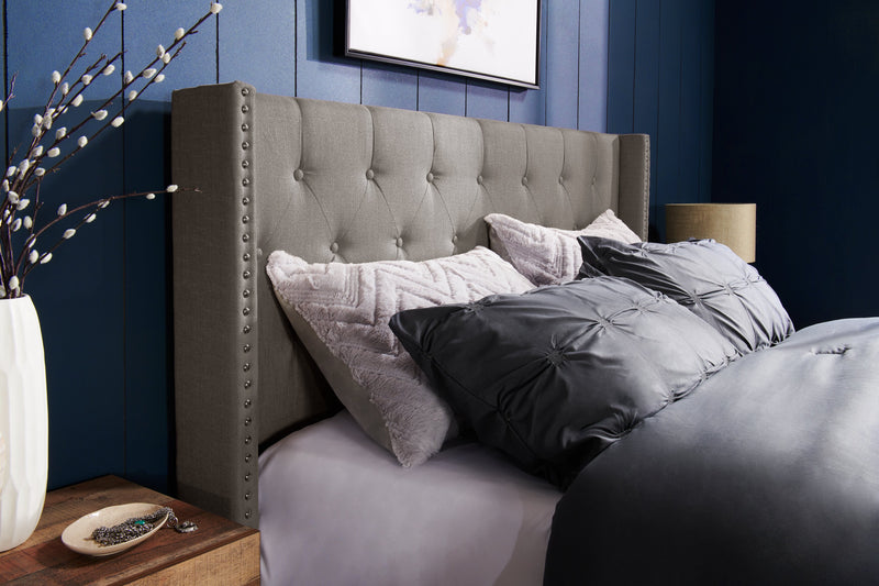 Lit rembourré à oreilles Brady en tissu gris clair avec clous décoratifs et capitonnage à boutons - format très grand lit